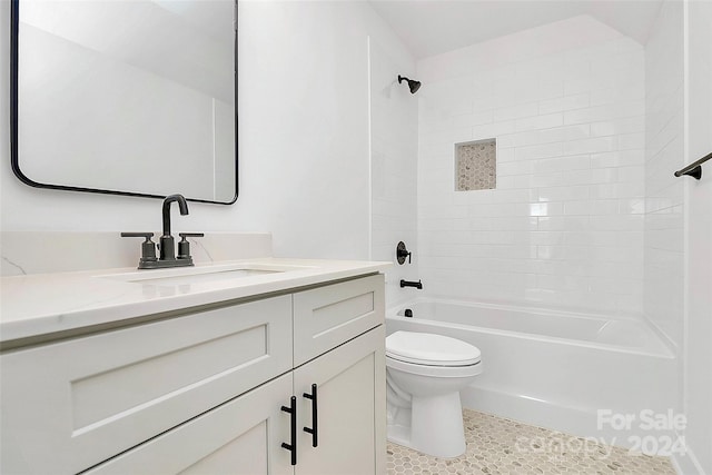 full bathroom featuring vanity, tiled shower / bath, and toilet