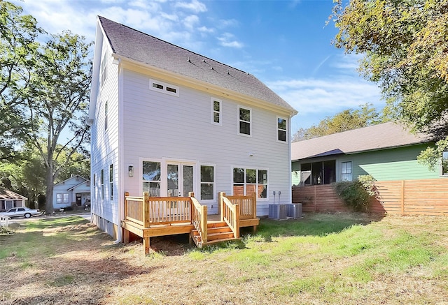 rear view of property with a wooden deck, cooling unit, and a lawn