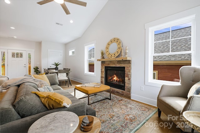 living room featuring a fireplace, high vaulted ceiling, and ceiling fan