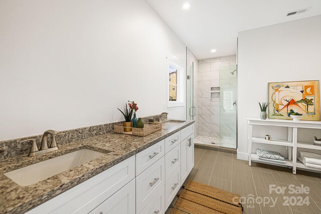 bathroom featuring vanity and an enclosed shower