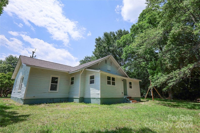 rear view of house featuring a yard