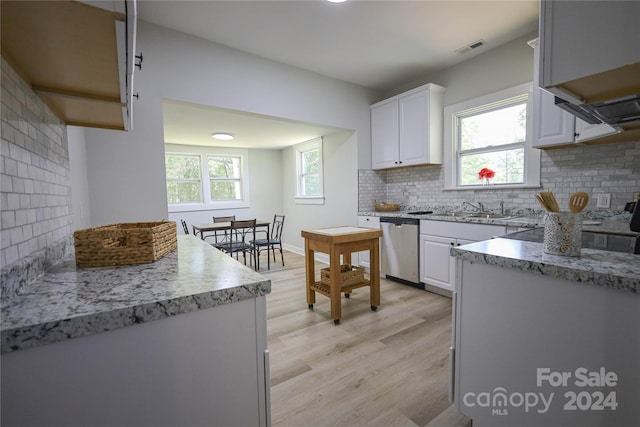 kitchen featuring sink, light wood-type flooring, dishwasher, white cabinets, and backsplash