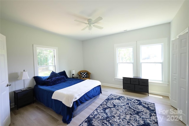 bedroom featuring multiple windows, ceiling fan, and light hardwood / wood-style floors