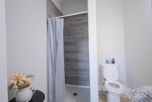 bathroom featuring walk in shower and toilet