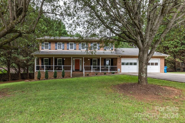 view of front facade featuring a porch, a garage, and a front lawn