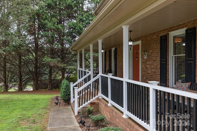 view of side of home featuring a lawn and covered porch