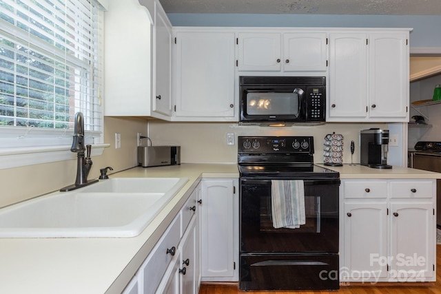 kitchen with white cabinets, sink, a textured ceiling, and black appliances