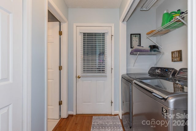 laundry area featuring washer and clothes dryer and light hardwood / wood-style flooring