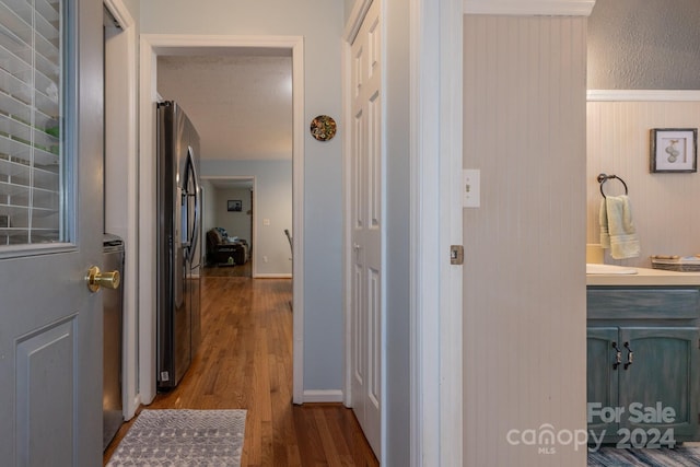 corridor with dark wood-type flooring and wood walls