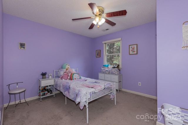 carpeted bedroom featuring ceiling fan and a textured ceiling