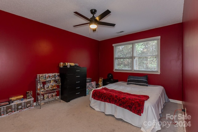 bedroom featuring carpet floors, a textured ceiling, and ceiling fan