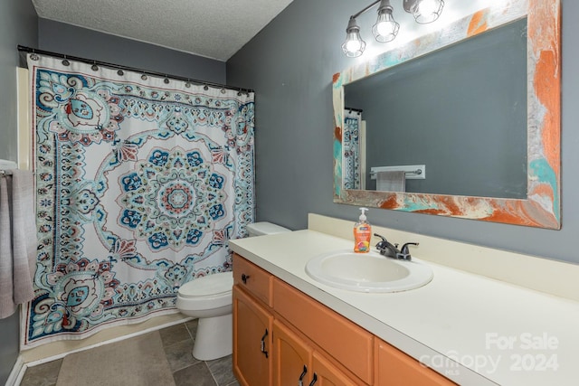 bathroom with vanity, toilet, a textured ceiling, and walk in shower