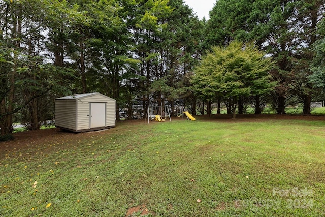 view of yard featuring a playground and a shed