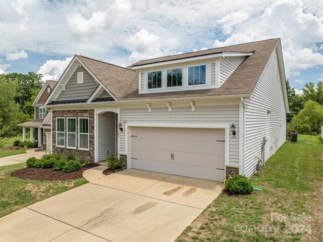 craftsman-style house with a garage and a front lawn