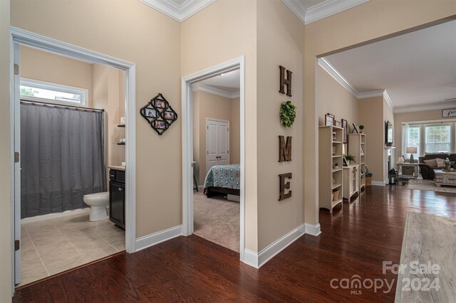 hall with ornamental molding and hardwood / wood-style floors