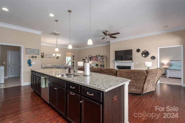 kitchen with ceiling fan, dark hardwood / wood-style flooring, an island with sink, sink, and light stone counters