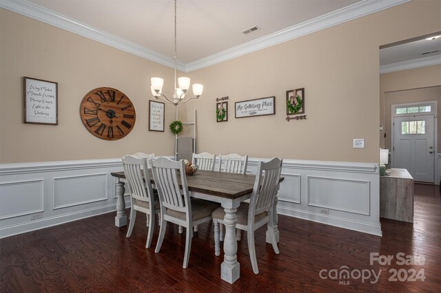 dining room featuring crown molding, dark hardwood / wood-style floors, and a chandelier