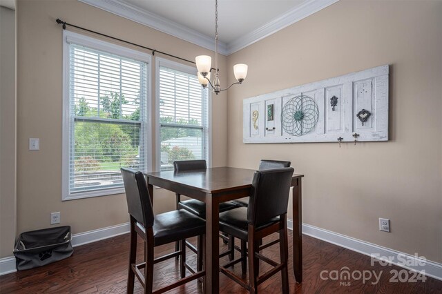 dining area featuring dark hardwood / wood-style floors, a chandelier, and ornamental molding