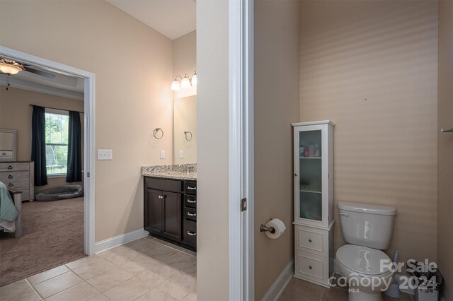 bathroom featuring vanity, tile patterned floors, ceiling fan, and toilet