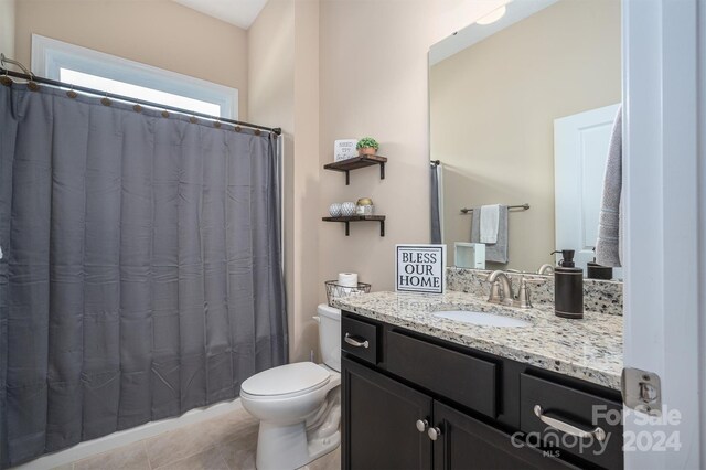 bathroom featuring vanity, tile patterned flooring, and toilet