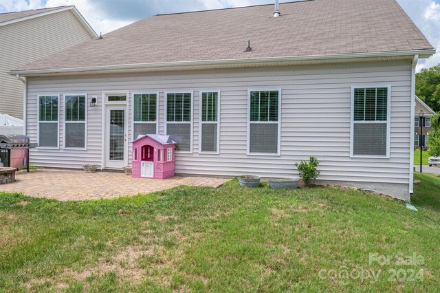 back of property with a patio area and a yard