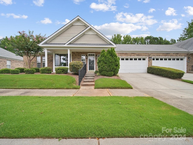 view of front of house featuring a garage, a porch, and a front lawn