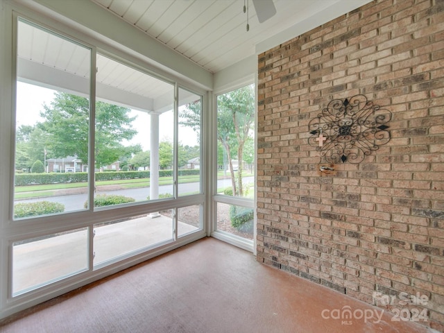 unfurnished sunroom with ceiling fan