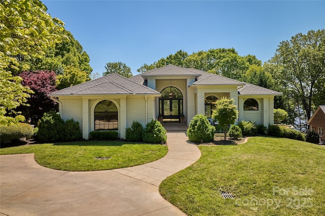 mediterranean / spanish-style house with french doors and a front yard