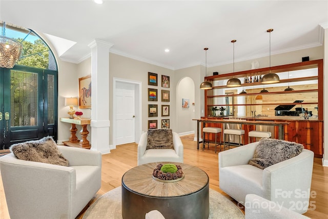 living room with crown molding and light wood-type flooring