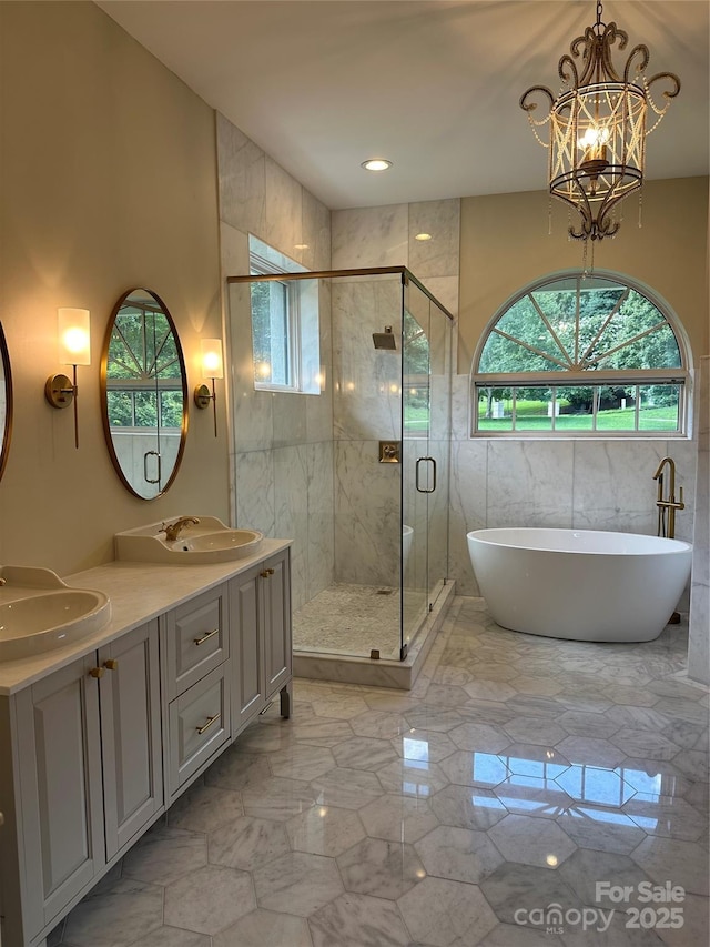 bathroom featuring vanity, a chandelier, and shower with separate bathtub