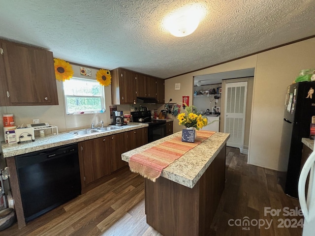 kitchen with a center island, sink, black appliances, dark hardwood / wood-style floors, and a textured ceiling