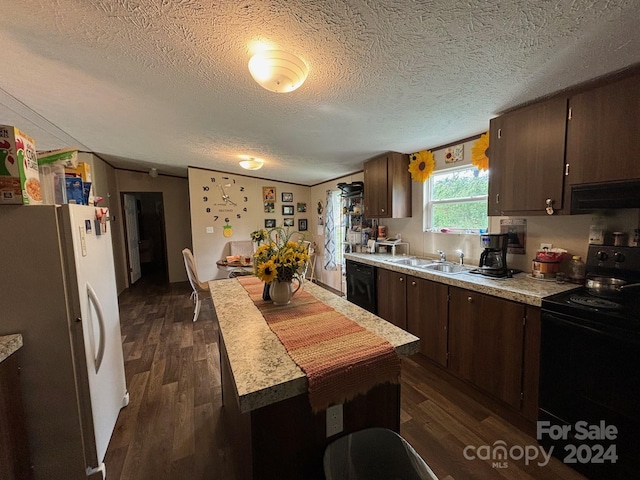 kitchen with sink, black appliances, extractor fan, dark wood-type flooring, and a textured ceiling