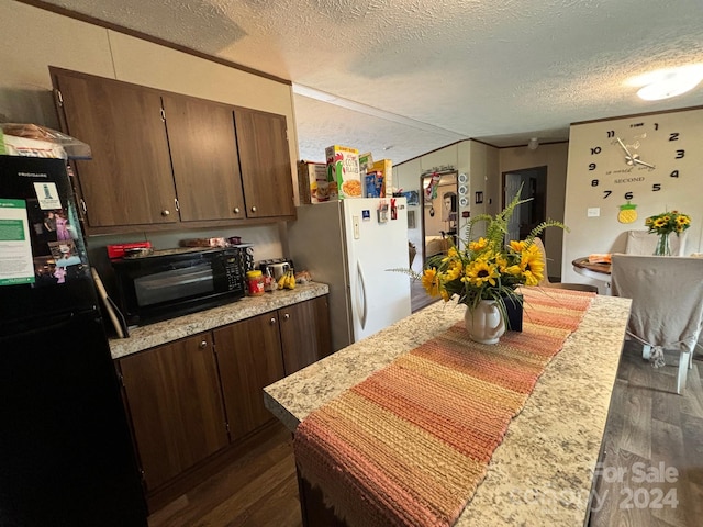 kitchen featuring black appliances, dark hardwood / wood-style floors, dark brown cabinets, and a textured ceiling