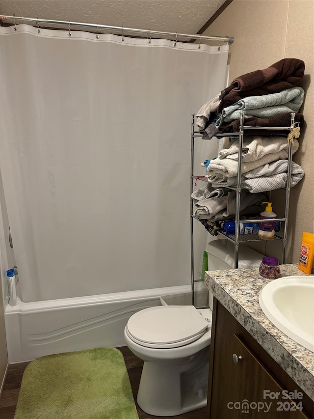 full bathroom with shower / bath combo with shower curtain, wood-type flooring, toilet, and vanity