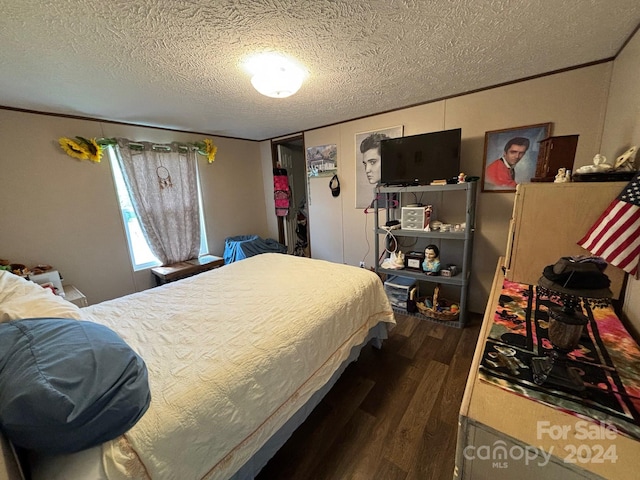 bedroom with a textured ceiling and dark wood-type flooring