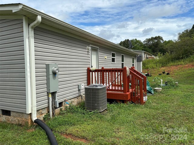 exterior space featuring a yard, a deck, and central AC