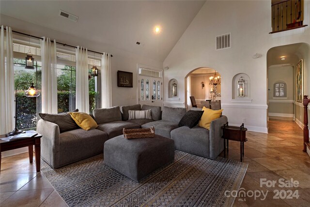 living room with a notable chandelier and high vaulted ceiling