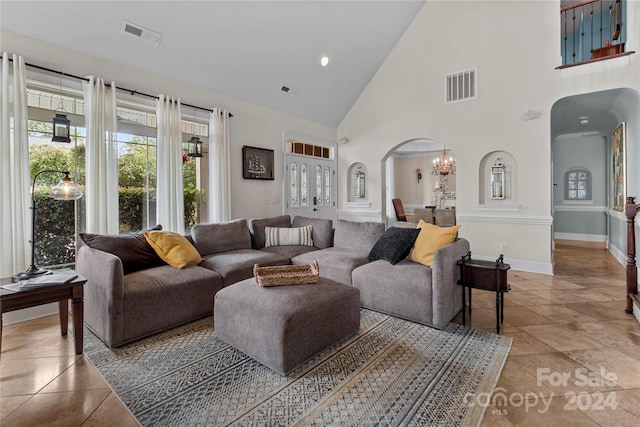 tiled living room featuring an inviting chandelier and high vaulted ceiling