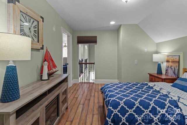 bedroom featuring hardwood / wood-style flooring and lofted ceiling