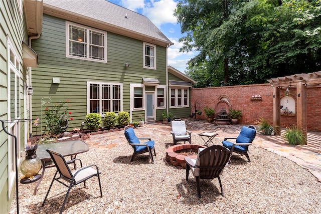 rear view of house with a patio and an outdoor fire pit