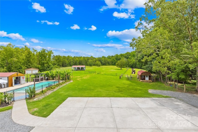 view of yard featuring a community pool, a storage shed, and a patio area