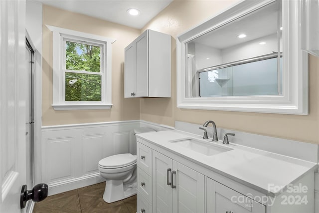 bathroom with vanity, an enclosed shower, and toilet