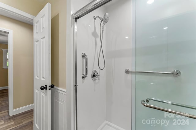 bathroom with wood-type flooring and a shower with door