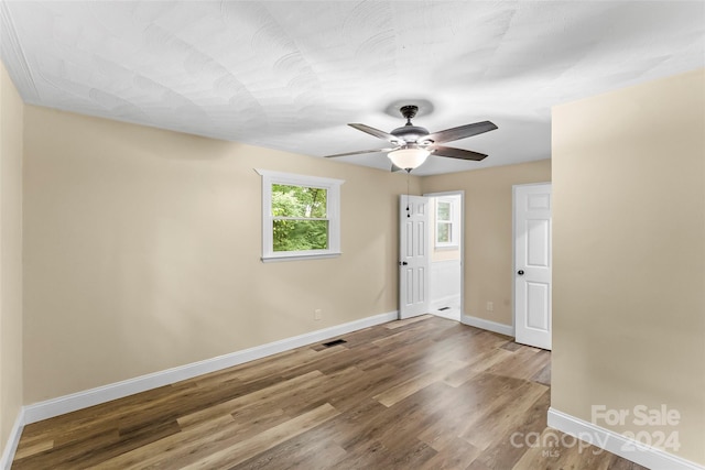 unfurnished room with hardwood / wood-style flooring and ceiling fan