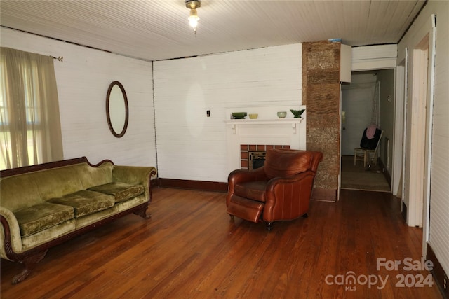 living room with wood-type flooring and a tile fireplace