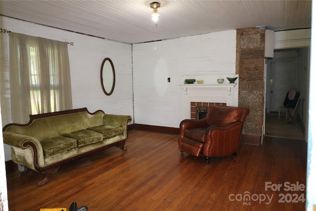 living room featuring a tiled fireplace and wood-type flooring