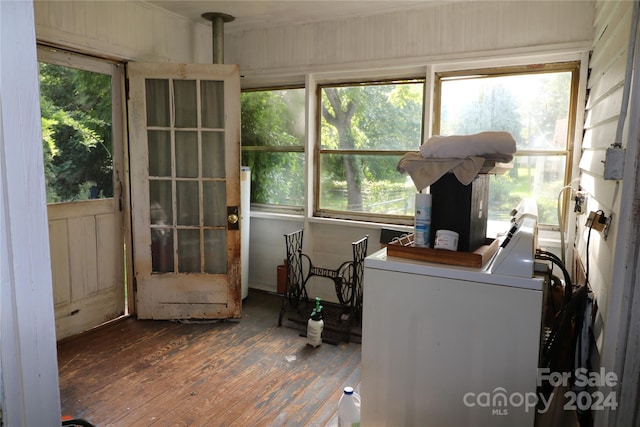 interior space with washer / clothes dryer, wood-type flooring, and a healthy amount of sunlight