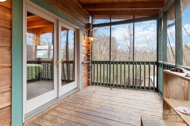 unfurnished sunroom featuring beamed ceiling and wooden ceiling