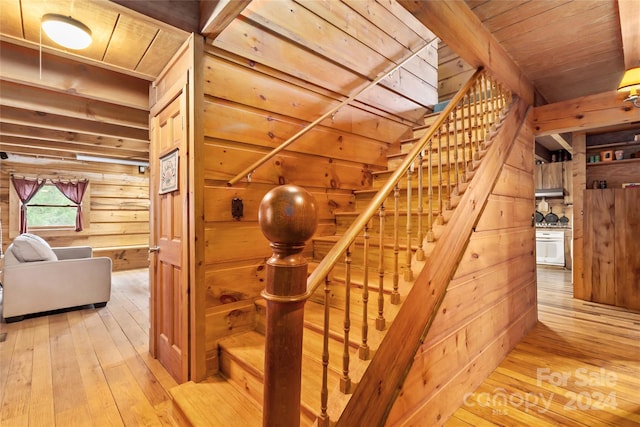 stairs with wood-type flooring, wood ceiling, and wood walls