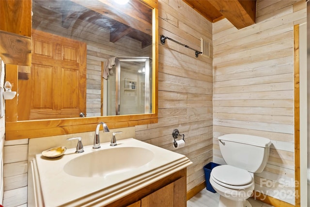 bathroom with vanity, a shower with door, toilet, and wood walls